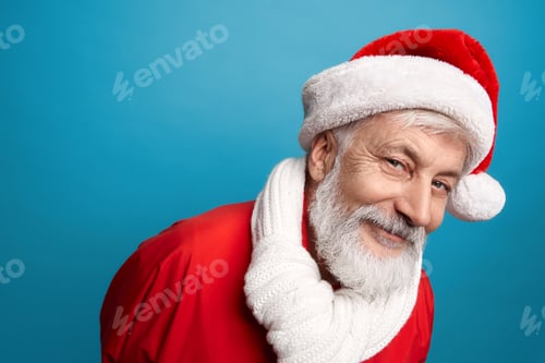 Preview: Bearded Santa Claus in red hat and white scarf in studio