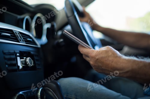 Preview: Man using mobile phone in car