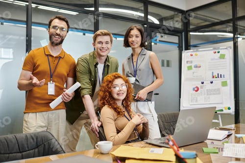 Preview: happy business team looking at camera near laptop in office, professional headshot, success