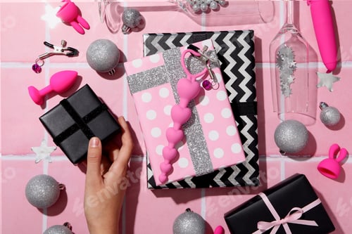 Preview: Sex toys with Christmas gifts on the background.