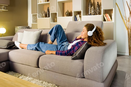 Preview: Young woman relaxing listening to music at home