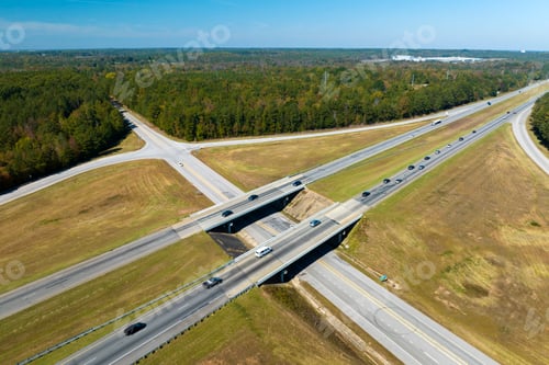 Preview: Elevated view of freeway exit junction over road lanes with fast moving traffic cars