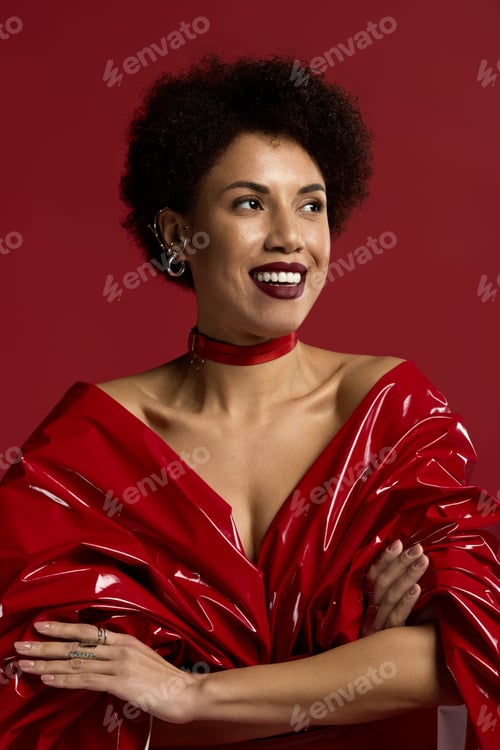 Preview: Captivating elegance showcased by a young woman in vibrant red attire against a bold backdrop
