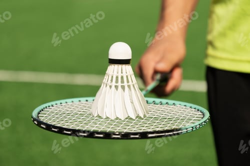 Preview: White badminton shuttlecock and badminton rackets on floor sport badminton. Outdoors. Close up.