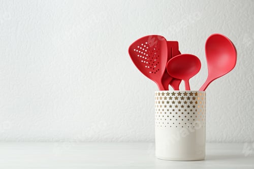 Preview: Set of kitchen utensils in stand on wooden table near light wall. Space for text