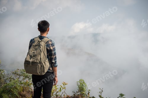 Preview: Hiker with backpacks standing on top of a mountain and enjoying nature view.