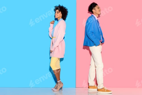 Preview: Happy couple standing back to back on pink and blue background