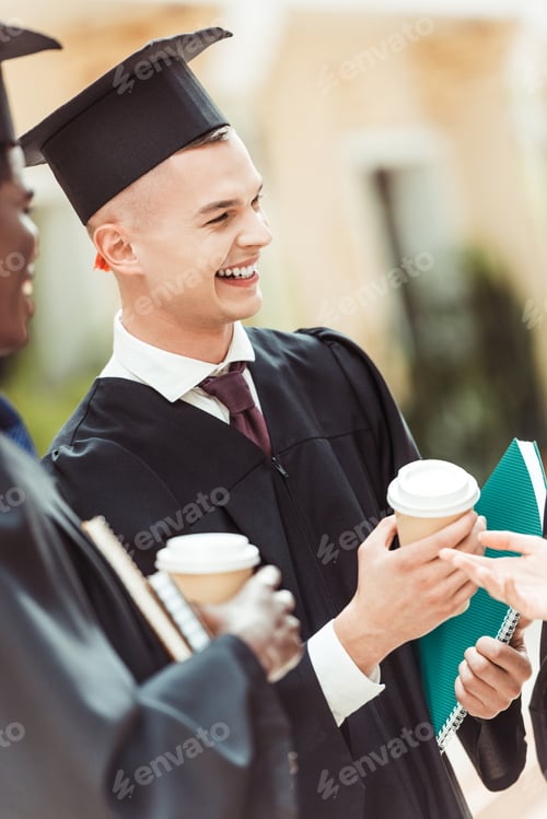 Preview: graduated happy multiethnic students with disposable cups of coffee