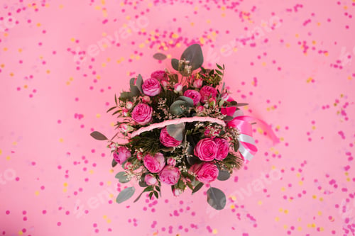 Preview: Romantic bouquet of pink roses and eucalyptus in basket on pink background with confetti