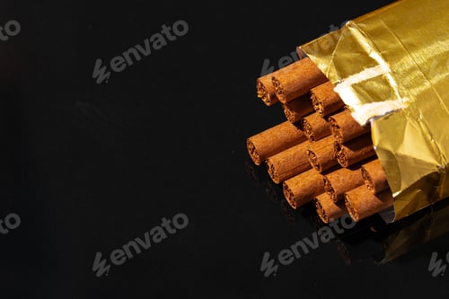 Preview: Golden pack of cigars on black background
