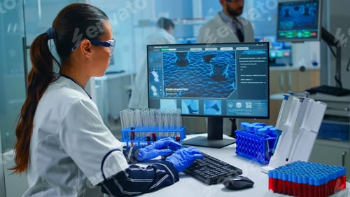Preview: Woman technologist doing a laboratory test examining a flask with blood sample
