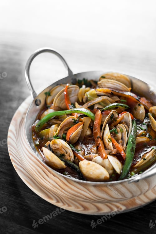 Preview: mediterranean clam and vegetable stew in pot at barcelona restaurant