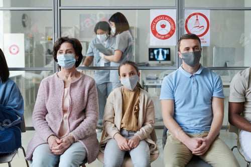 Preview: Row of mature woman, little girl, young man and others in protective masks
