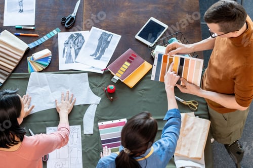 Preview: Group of young fashion designers discussing textile samples for new seasonal collection