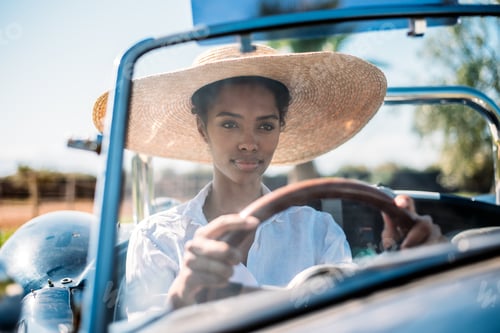 Preview: Black woman driving a vintage convertible car