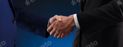 Preview: Business partners shaking hands on dark blue background, closeup