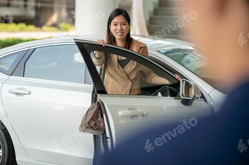 Visualização: Parte traseira da recepcionista dando as boas-vindas à cliente asiática para visitar o centro de serviços de manutenção