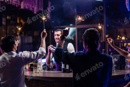 Preview: Caucasian profession bartender making a cocktail for young men at a bar.