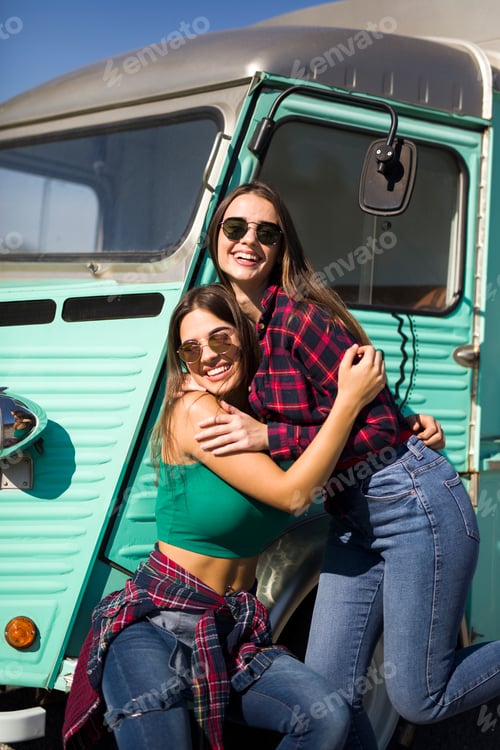 Preview: Smiling young women by the vintage minivan