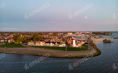 Preview: Urk Flevoland Netherlands sunset at the lighthouse and harbor of Urk Holland. Fishing village Urk