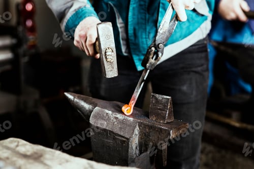 Preview: Closeup shot of a blacksmith forging a hinge on an anvil