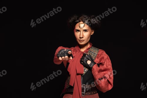 Preview: front view of beautiful steampunk woman pointing with finger at camera isolated on black