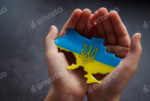 Preview: Hands holding the shape of Ukraine border with color flag