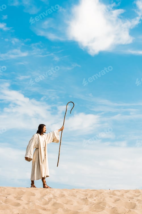 Preview: handsome man in jesus robe holding wooden cane