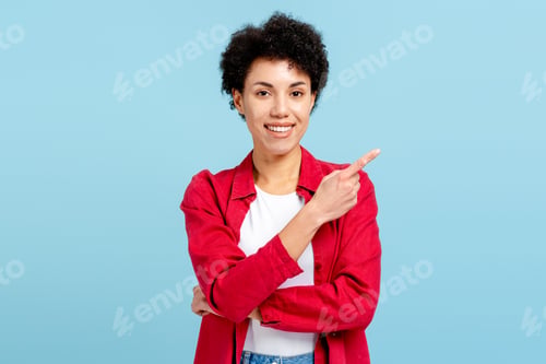 Preview: Smiling woman pointing finger to the side showing copy space, recommending offer