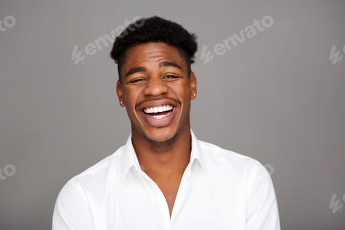 Preview: Close up handsome young black man laughing against gray background