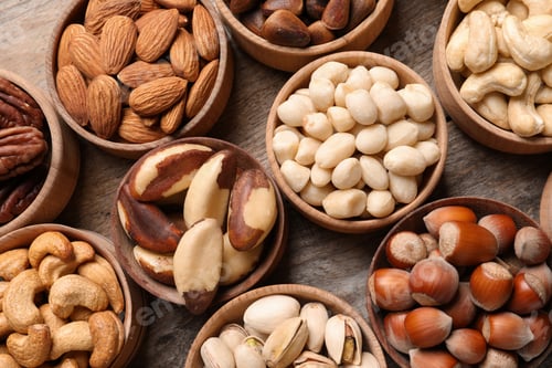 Preview: Flat lay composition with organic nuts on wooden background, top view. Snack mix