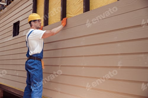 Preview: Male worker building house at construction site