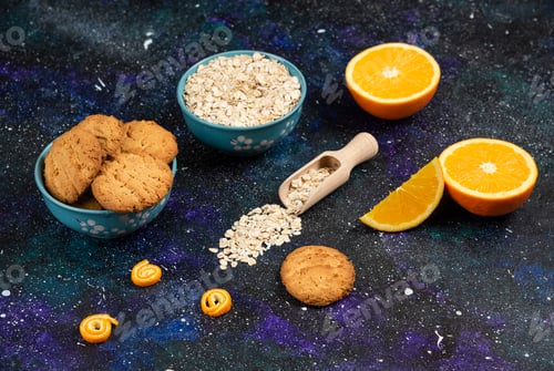 Preview: homemade cookies with oatmeal in bowls and orange over space background