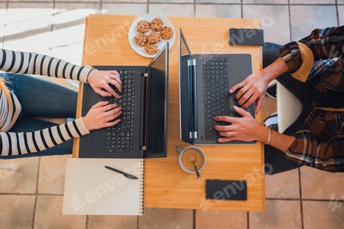 Preview: Man and woman sitting at table with laptops at home