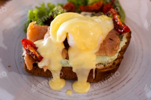 Preview: Close up of a breakfast sandwich of toasted bread, poached egg and melted cheese.