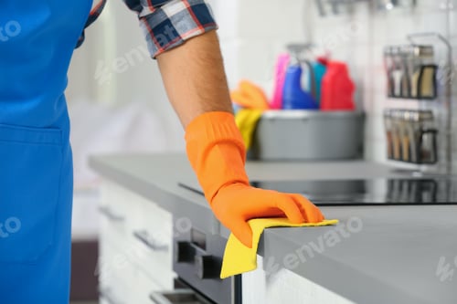 Preview: Man cleaning kitchen counter with rag, closeup