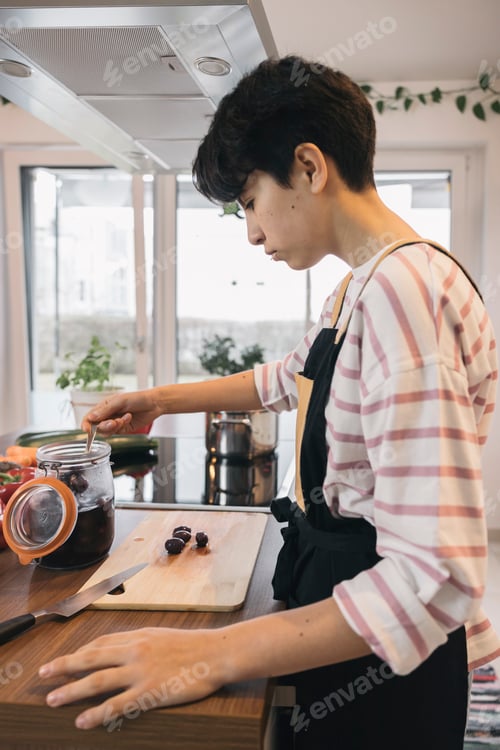 Preview: Teenager preparing a healthy meal in a modern kitchen