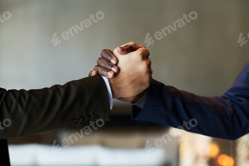 Preview: Close-up of hands of two young male business partners in handshake