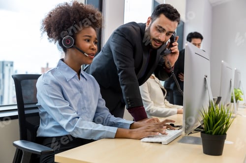 Preview: Call center business woman talking on headset. Call center worker accompanied by her team.