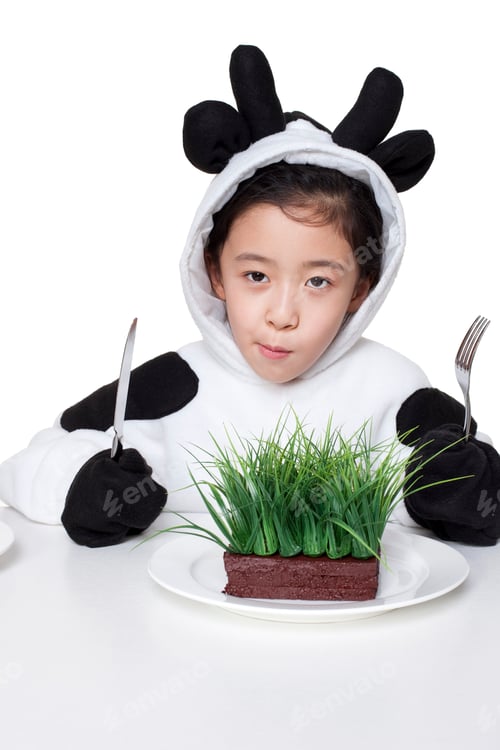 Preview: Girl in a cow costume with a serving of grass on her plate