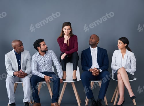 Preview: Studio shot of a group of corporate businesspeople waiting in line against a gray background