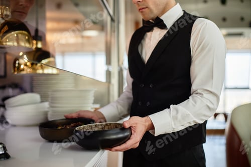 Preview: Young Adult Caucasian Man Serving Food in Restaurant Kitchen Interior