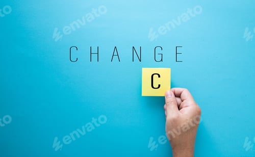 Preview: Hand holding the letter C to change the word Change into Chance on a blue background