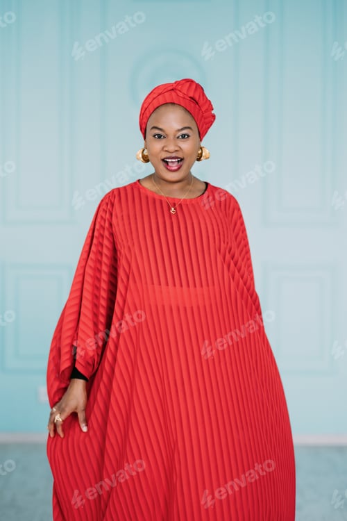 Preview: Beautiful positive african american woman wearing red ethnic clothes and headscarf, walking on
