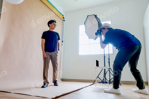 Preview: Model Poses While Photographer Takes Picture In Studio