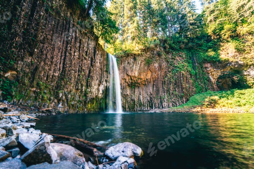 Preview: Wide shot of a beautiful waterfall and a small lake in a forest on a sunny day