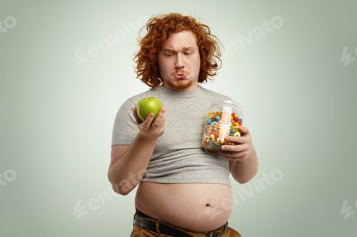 Preview: Studio shot of thoughtful indecisive redhead overweight fat man with big stomach feeling confused an