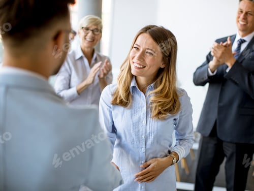 Preview: Young business partners making handshake in an office