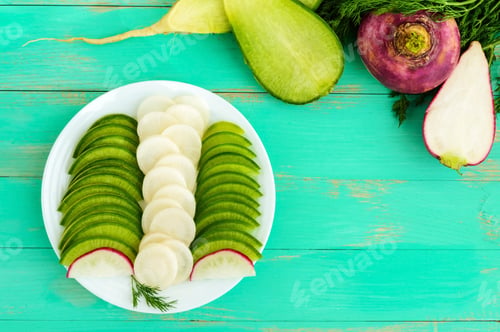 Preview: Several kinds of radish sliced on a white plate on a light wooden background. The top view