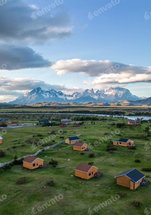 Preview: Aerial view of small wooden cabins on a green landscape in Torres del Paine, Chile.